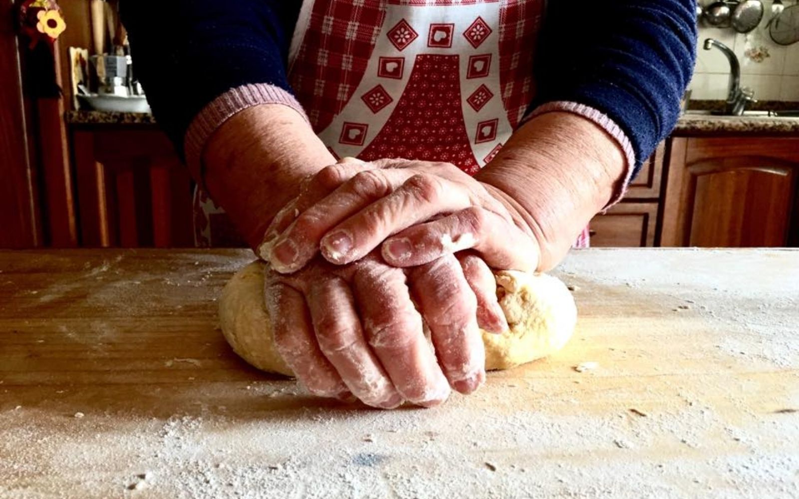 M&atilde;os preparando massa em uma cozinha italiana tradicional