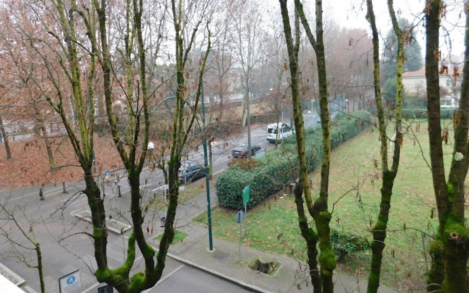 Vista de uma rua arborizada na It&aacute;lia a partir da hospedagem